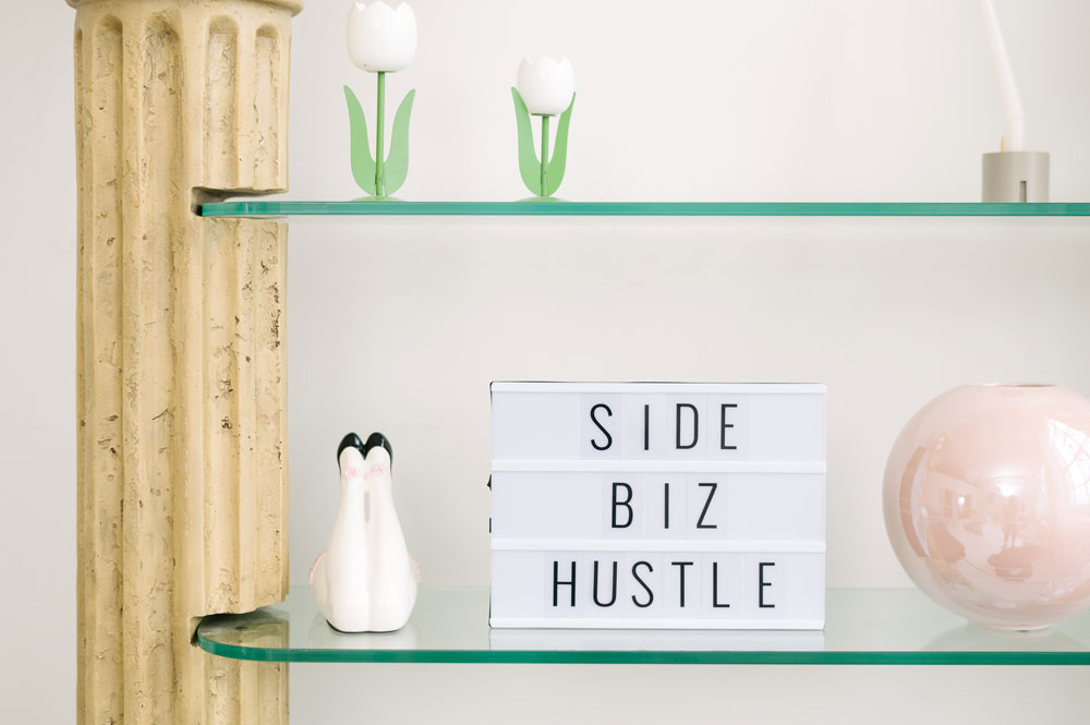 A sign on a shelf that reads, "Side biz hustle."
